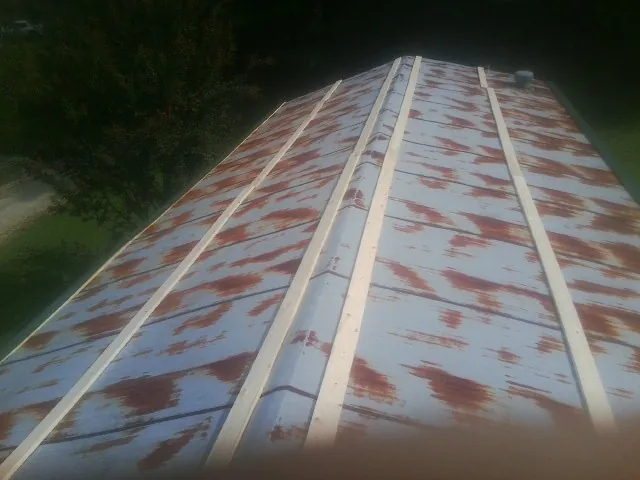 Rusted metal roof panels with new wood purlins before replacement — Storm Damage Roof Repair in Roseboro by Roofing Brothers
