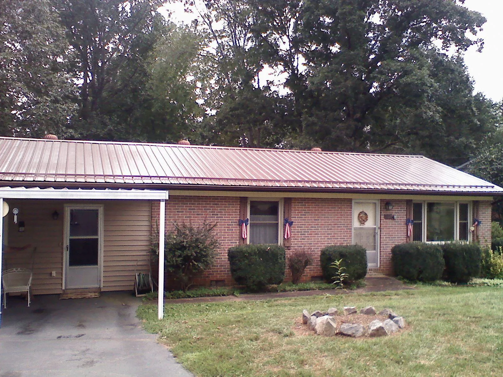 Bronze metal roof and carport on a brick ranch home — Roof Repair work by our crew in Roseboro
