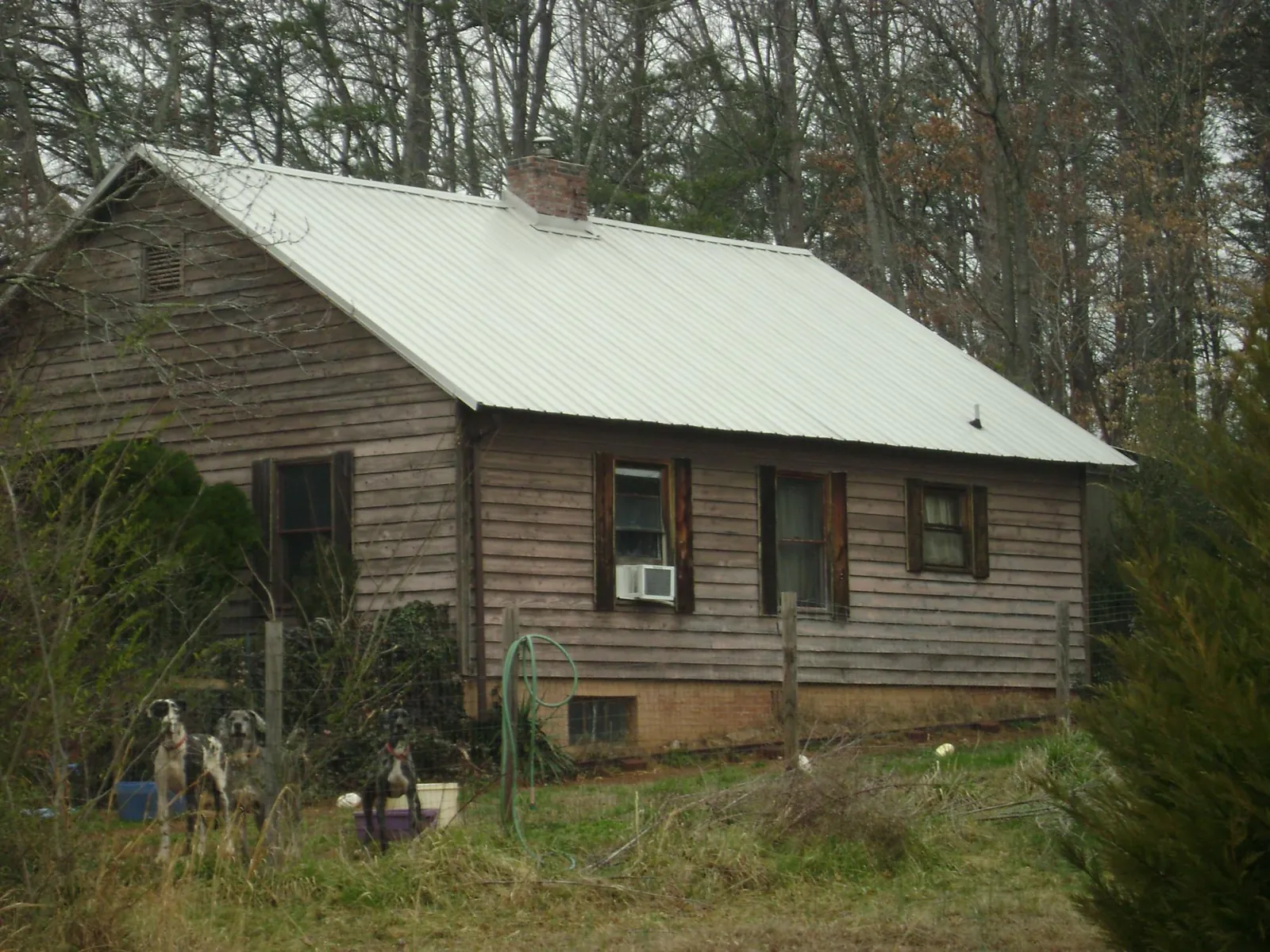 White metal roof on an old wood sided farmhouse, from a Metal Roof Installation job in Roseboro